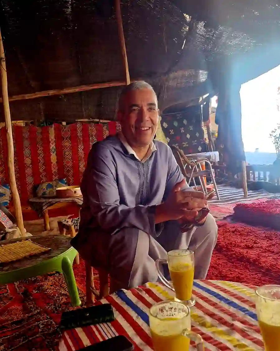 Mohamed Kimou sharing traditional tea in a Berber desert camp