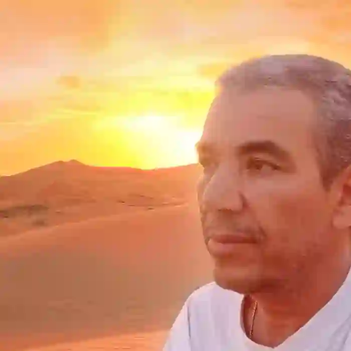 Mohamed Kimou watching the sunset over the Sahara dunes